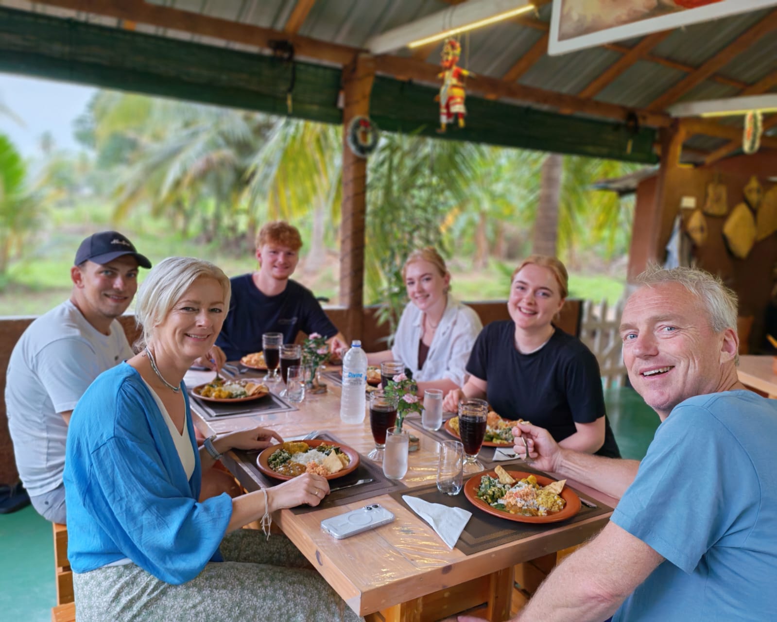Family and guests sharing Sri Lankan rice and curry meal together